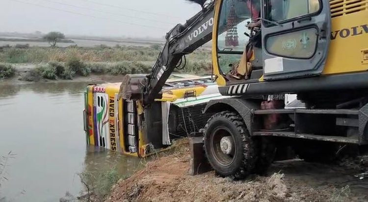 A crane operator attempts to recover an overturned bus from a water canal in Pakistan's southern district of Thatta on July 20, 2025. (Rescue Service Thatta)