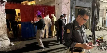 Police officials inspect the site following a suicide bombing during a protest in Swat district on August 2. — AFP